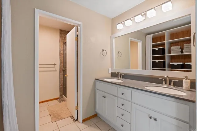 a bathroom with a granite countertop sink a mirror and a shower