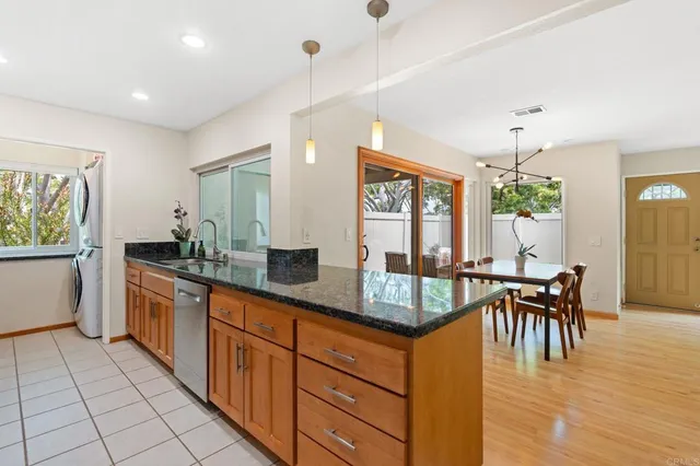 a kitchen with granite countertop cabinets a dining table and a stove