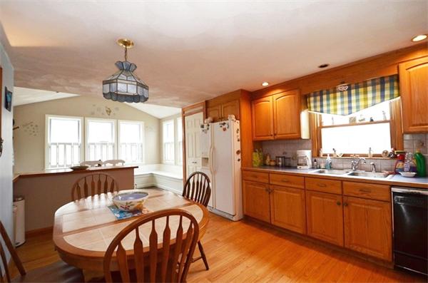 8 Riverside Road Billerica, MA 01821 - Photo 6 of 30 a kitchen with stainless steel appliances granite countertop a stove a sink dishwasher a dining table and chairs with wooden floor