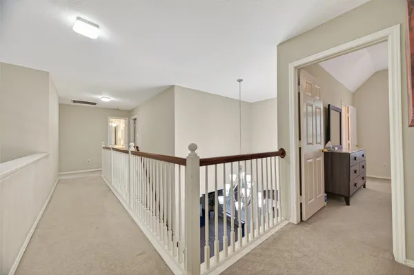 a view of a hallway with a white door and stairs