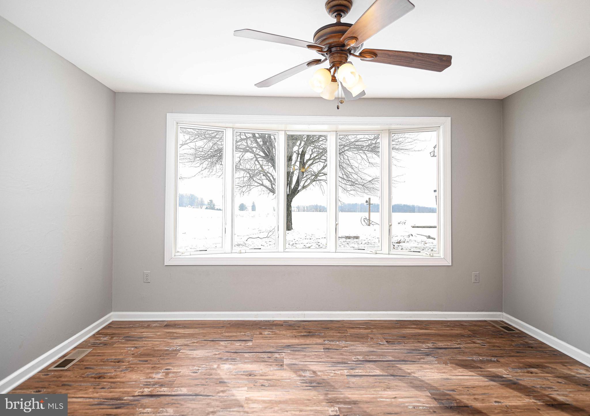 754 Main Street Fawn Grove, PA 17321 - Photo 12 of 40 an empty room with wooden floor fan and windows
