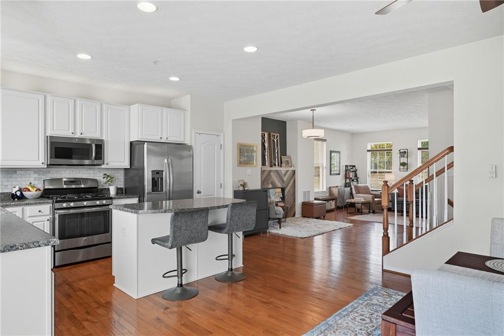 11 Truman Circle McKees Rocks, PA 15136 - Photo 11 of 33 a kitchen with stainless steel appliances granite countertop a refrigerator a stove top oven a sink dishwasher and white cabinets with wooden floor