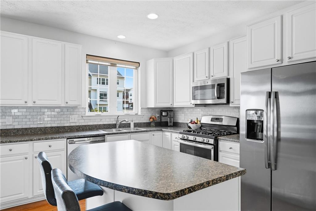 11 Truman Circle McKees Rocks, PA 15136 - Photo 12 of 33 a kitchen with stainless steel appliances granite countertop a sink a stove a refrigerator cabinets and a window