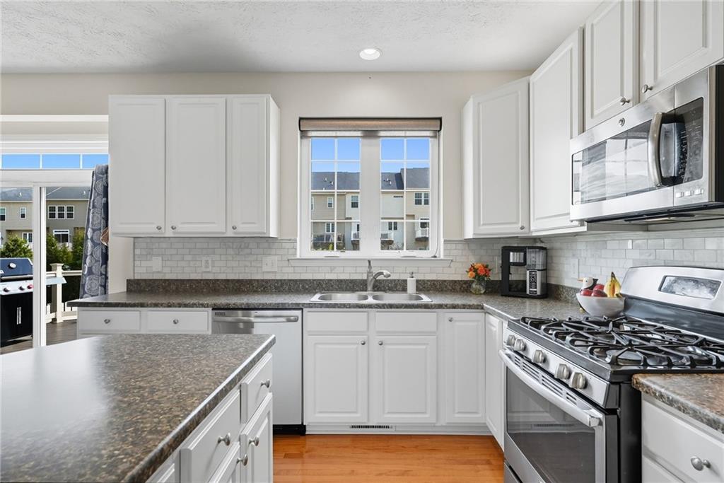 11 Truman Circle McKees Rocks, PA 15136 - Photo 13 of 33 a kitchen with stainless steel appliances granite countertop a sink stove and cabinets