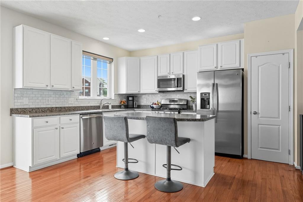 11 Truman Circle McKees Rocks, PA 15136 - Photo 10 of 33 a kitchen with stainless steel appliances granite countertop a refrigerator a stove top oven and a hard wood floors