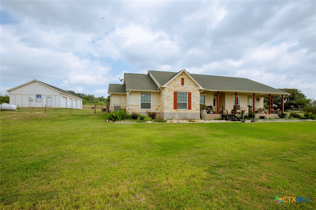 a view of a big house with a big yard and large trees