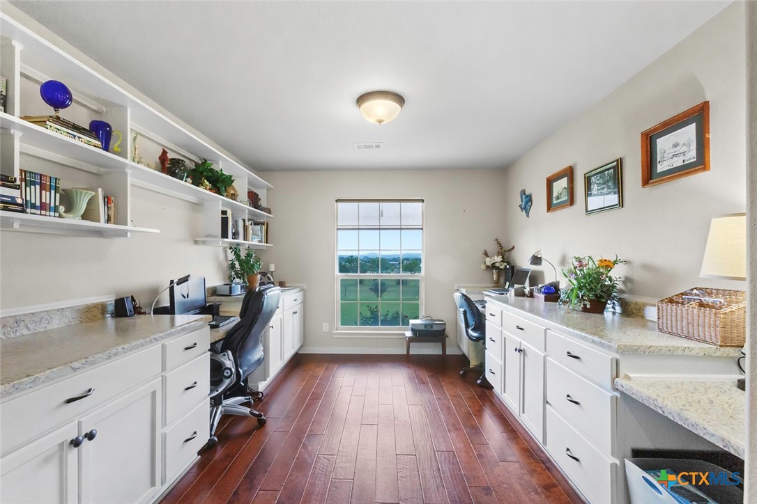 187 Tracks Trail Center Point, TX 78010 - Photo 17 of 41 a kitchen that has a lot of white cabinets and wooden floor