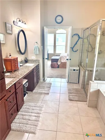a large bathroom with a tub sink and mirror