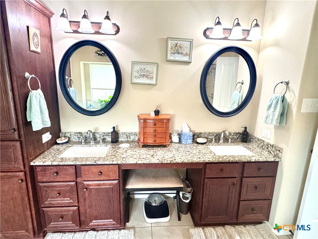 187 Tracks Trail Center Point, TX 78010 - Photo 22 of 41 a bathroom with a granite countertop double vanity sink and a mirror