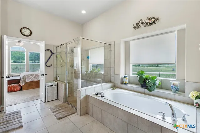 a bathroom with a granite countertop tub sink and glass door shower