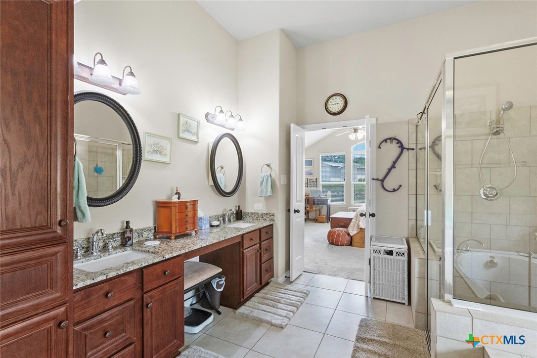 187 Tracks Trail Center Point, TX 78010 - Photo 24 of 41 a bathroom with a granite countertop sink a mirror and a shower