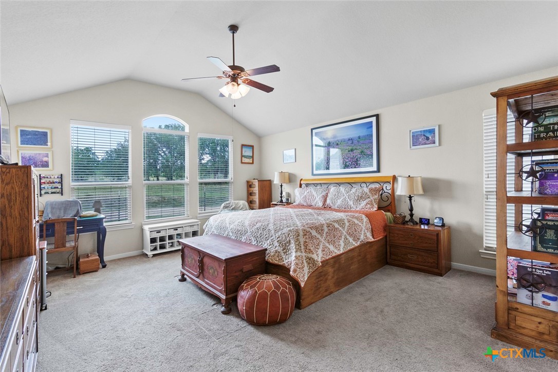 187 Tracks Trail Center Point, TX 78010 - Photo 25 of 41 a spacious bedroom with a bed and a chandelier
