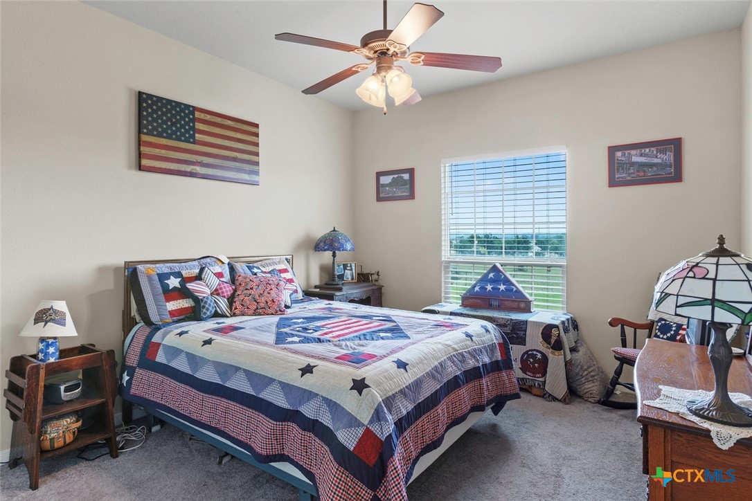 187 Tracks Trail Center Point, TX 78010 - Photo 29 of 41 a bedroom with a bed and a chandelier