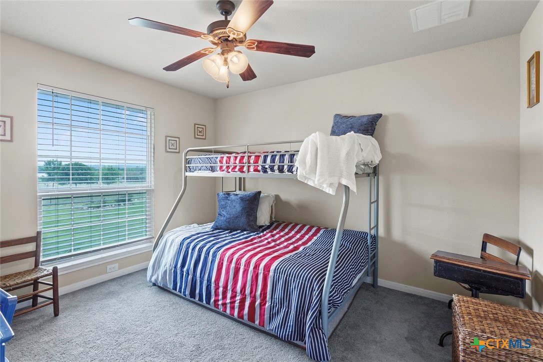 187 Tracks Trail Center Point, TX 78010 - Photo 31 of 41 a bedroom with a bed and a chandelier