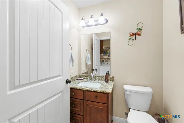 a bathroom with a toilet a sink and mirror
