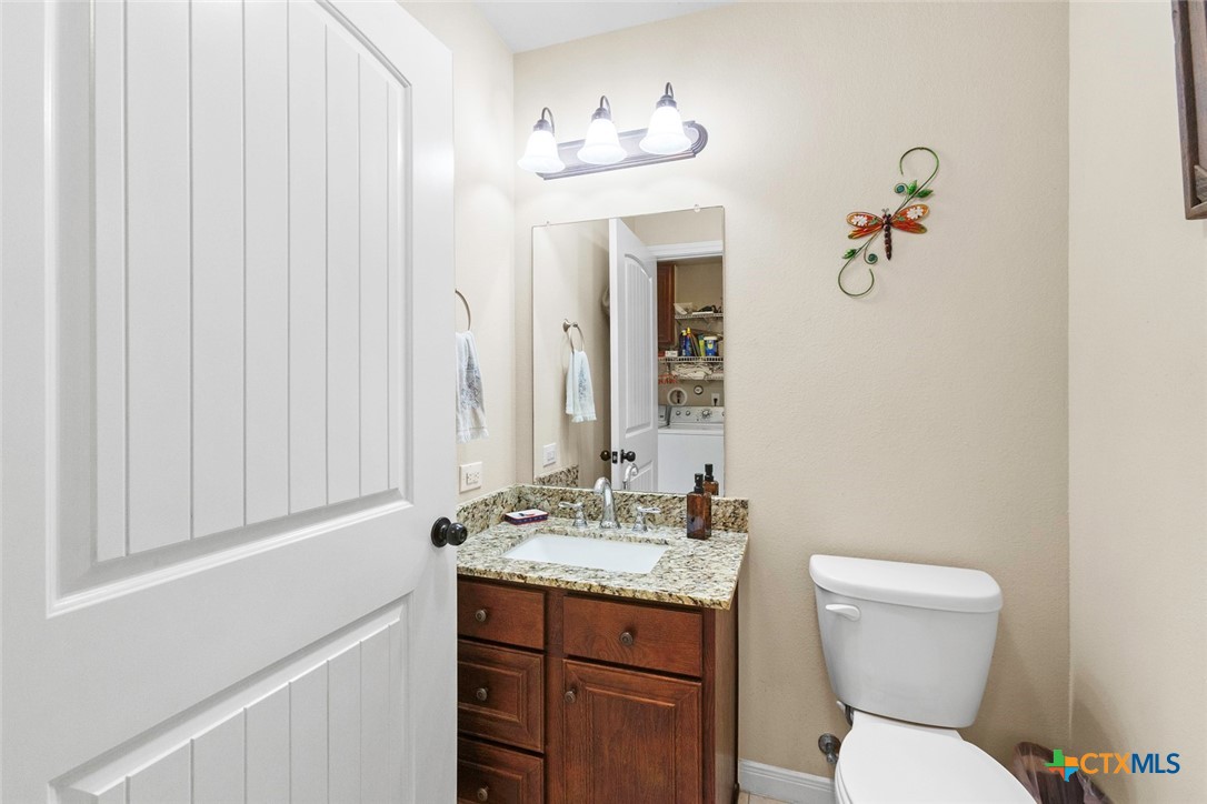 187 Tracks Trail Center Point, TX 78010 - Photo 33 of 41 a bathroom with a toilet a sink and mirror