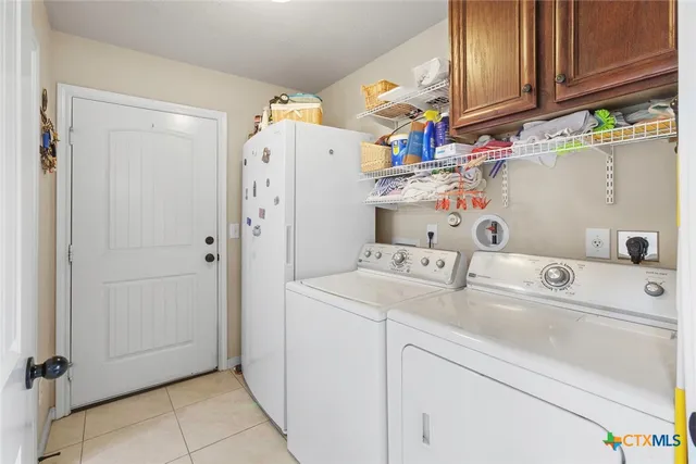a utility room with cabinets washer and dryer
