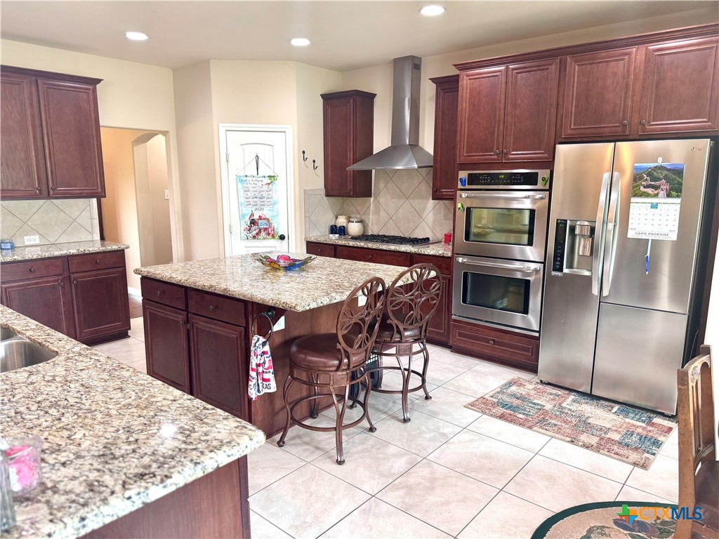187 Tracks Trail Center Point, TX 78010 - Photo 10 of 41 a kitchen with stainless steel appliances kitchen island granite countertop a refrigerator a stove a sink a table and chairs