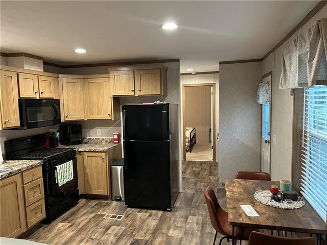 a kitchen with stainless steel appliances granite countertop a refrigerator stove top oven a sink and dishwasher