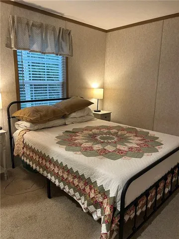 a bed sitting in a bedroom next to a lamp