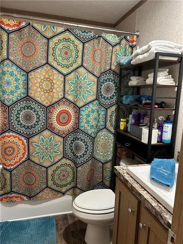 a bathroom with a granite countertop sink a toilet and a mirror