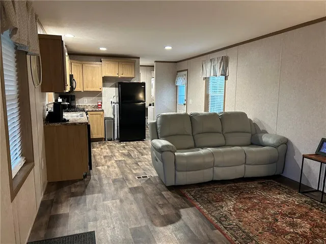 a living room with furniture and a refrigerator