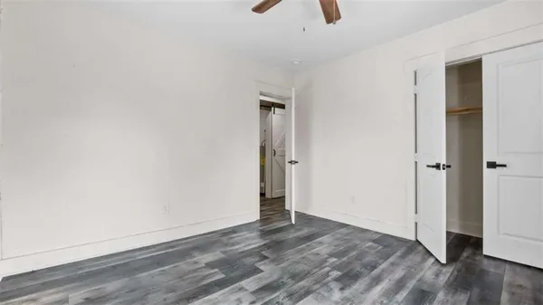 an empty room with wooden floor and closet