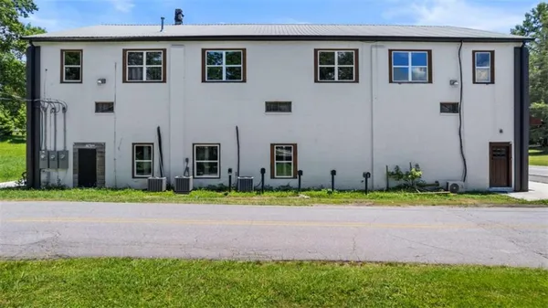 a front view of a house with a yard and trees