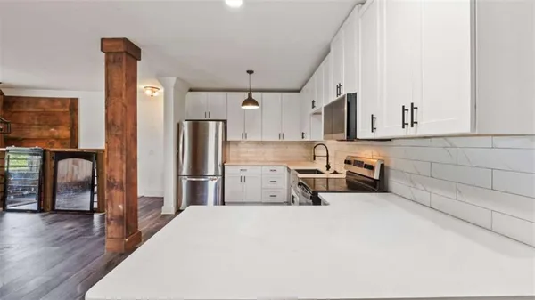 a kitchen with stainless steel appliances a refrigerator and wooden floor