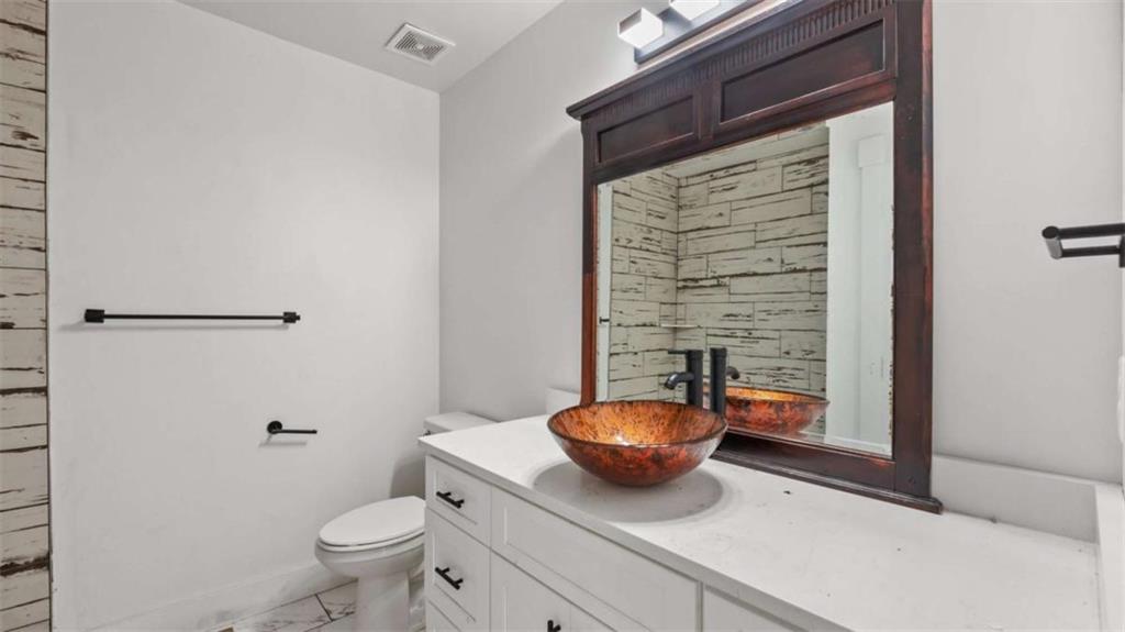 610 Madola Road, Unit 3 Epworth, GA 30541 - Photo 9 of 15 a bathroom with a granite countertop toilet and a sink