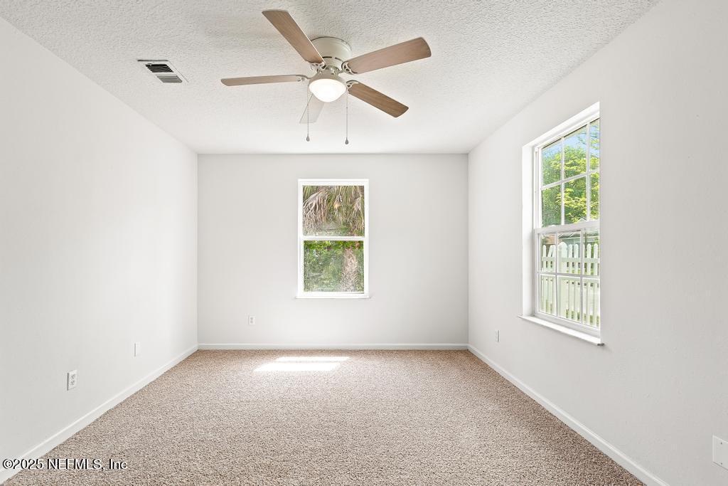 3701 Stuart Street Jacksonville, FL 32209 - Photo 20 of 24 an empty room with windows and ceiling fan