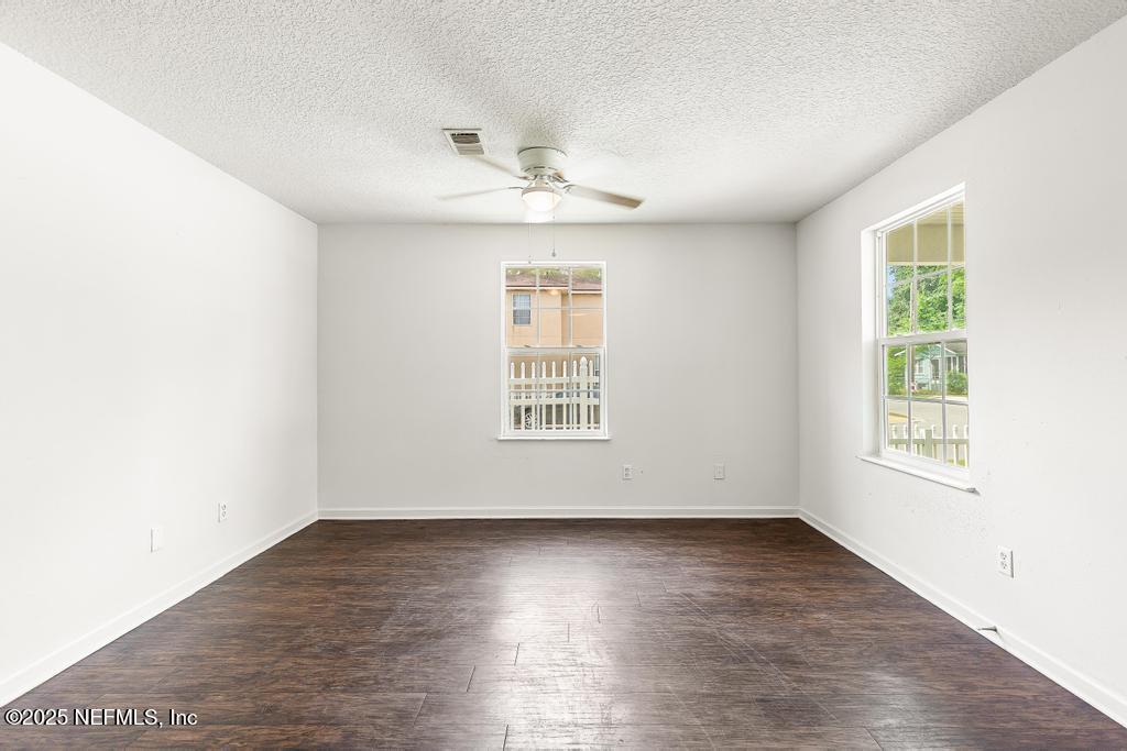 3701 Stuart Street Jacksonville, FL 32209 - Photo 5 of 24 an empty room with wooden floor chandelier fan and windows