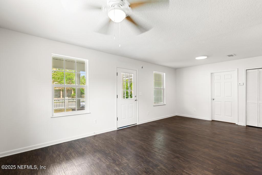 3701 Stuart Street Jacksonville, FL 32209 - Photo 6 of 24 an empty room with wooden floor chandelier fan and windows