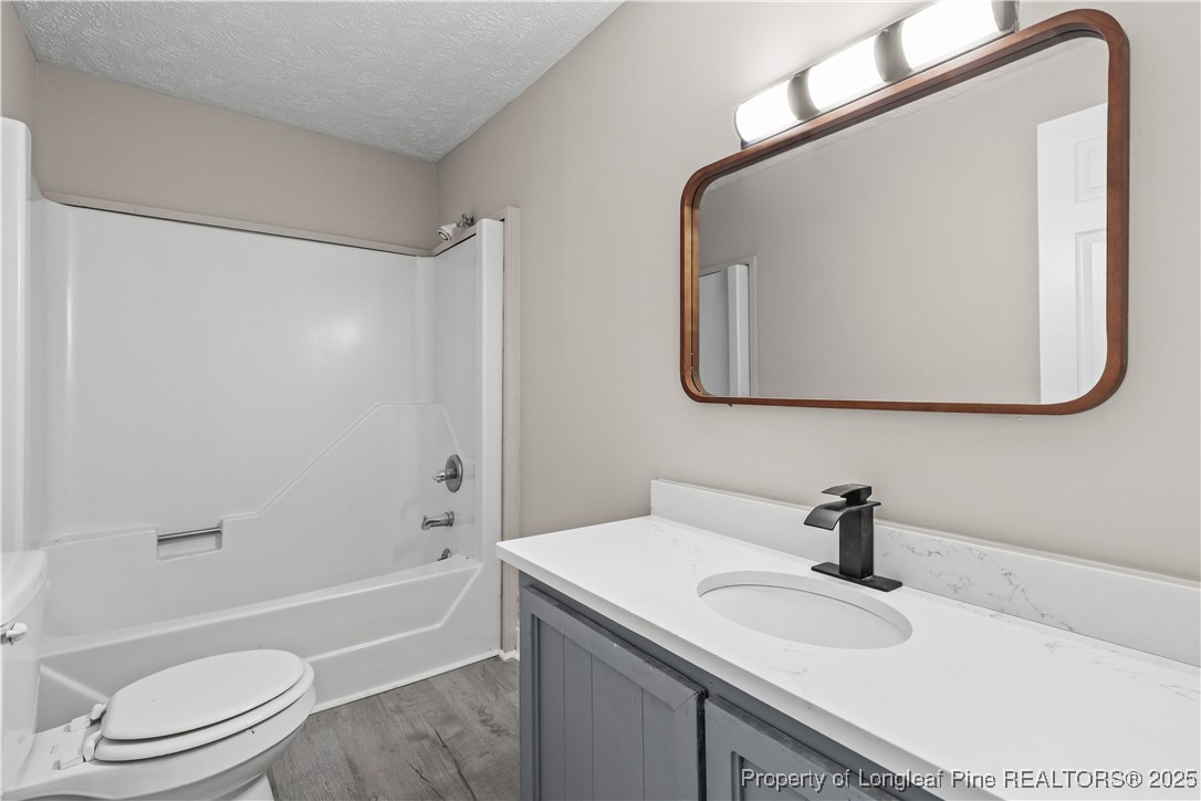 2302 Odom Road Hope Mills, NC 28348 - Photo 17 of 33 a bathroom with a granite countertop sink toilet and shower