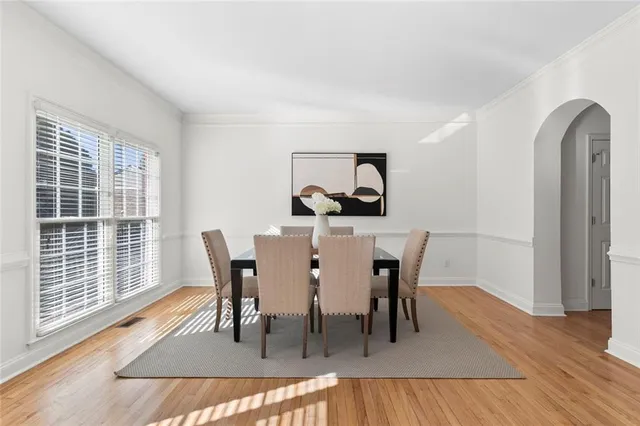 a dining room with furniture a window and wooden floor