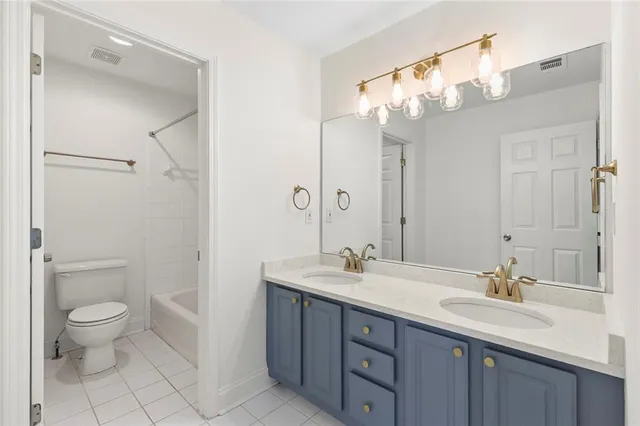 a bathroom with a double vanity sink mirror and toilet