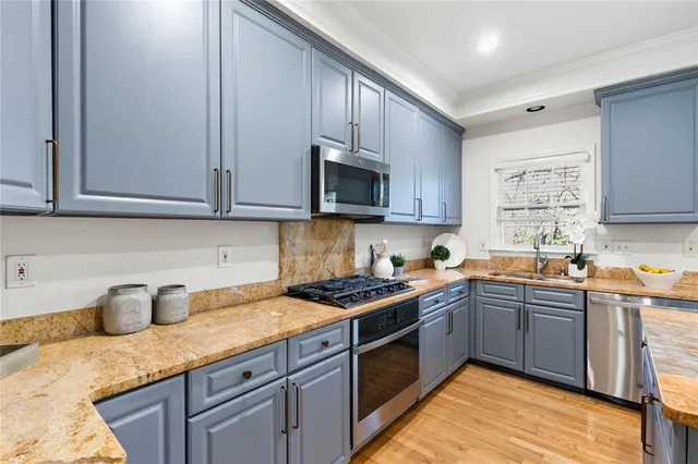 a kitchen with stainless steel appliances granite countertop a sink stove and cabinets