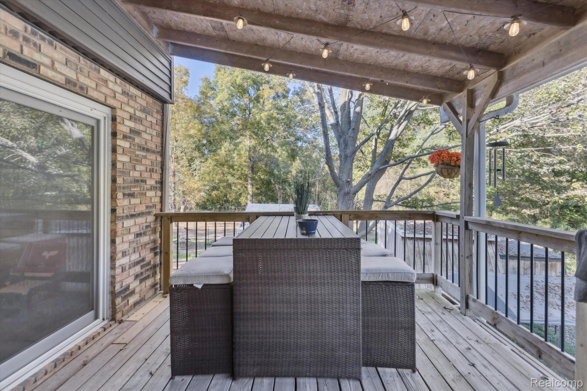 10147 South Bray Road Clio, MI 48420 - Photo 2 of 57 Wooden terrace featuring outdoor dining area and view of wooded area