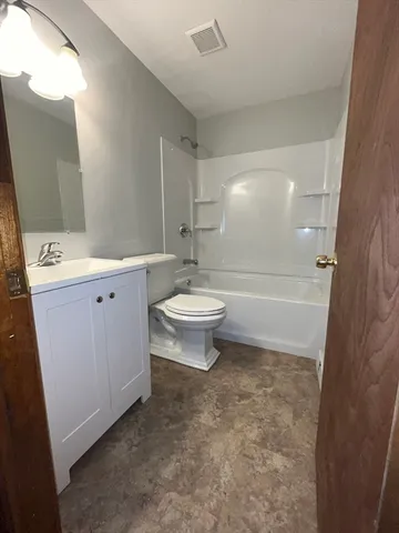 a bathroom with a sink a toilet a mirror and shower