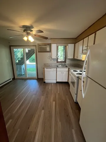 a kitchen with wooden floors and refrigerator