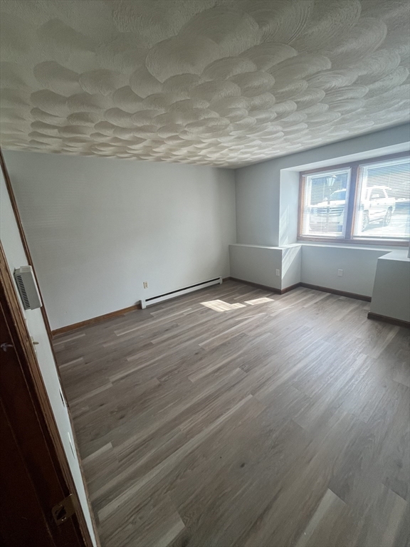35 School Street, Unit 7 Dracut, MA 01826 - Photo 9 of 22 a view of an empty room with wooden floor and a window