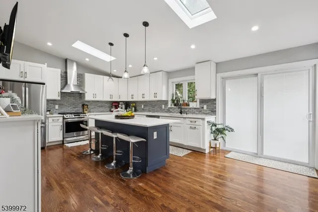 a kitchen with stainless steel appliances granite countertop a stove a sink a refrigerator and a microwave