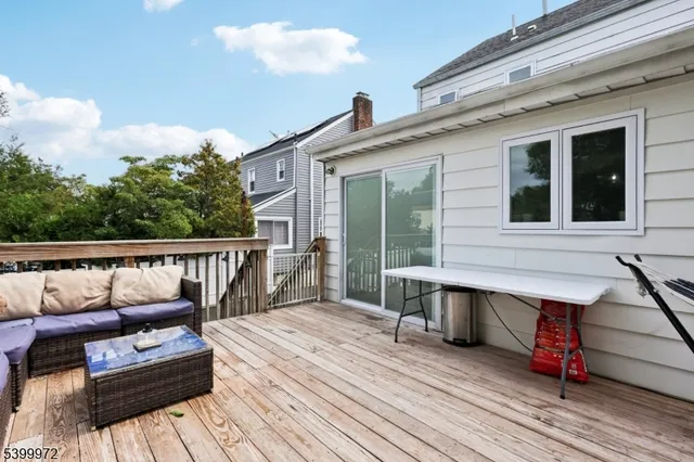 a balcony with wooden floor table and chairs