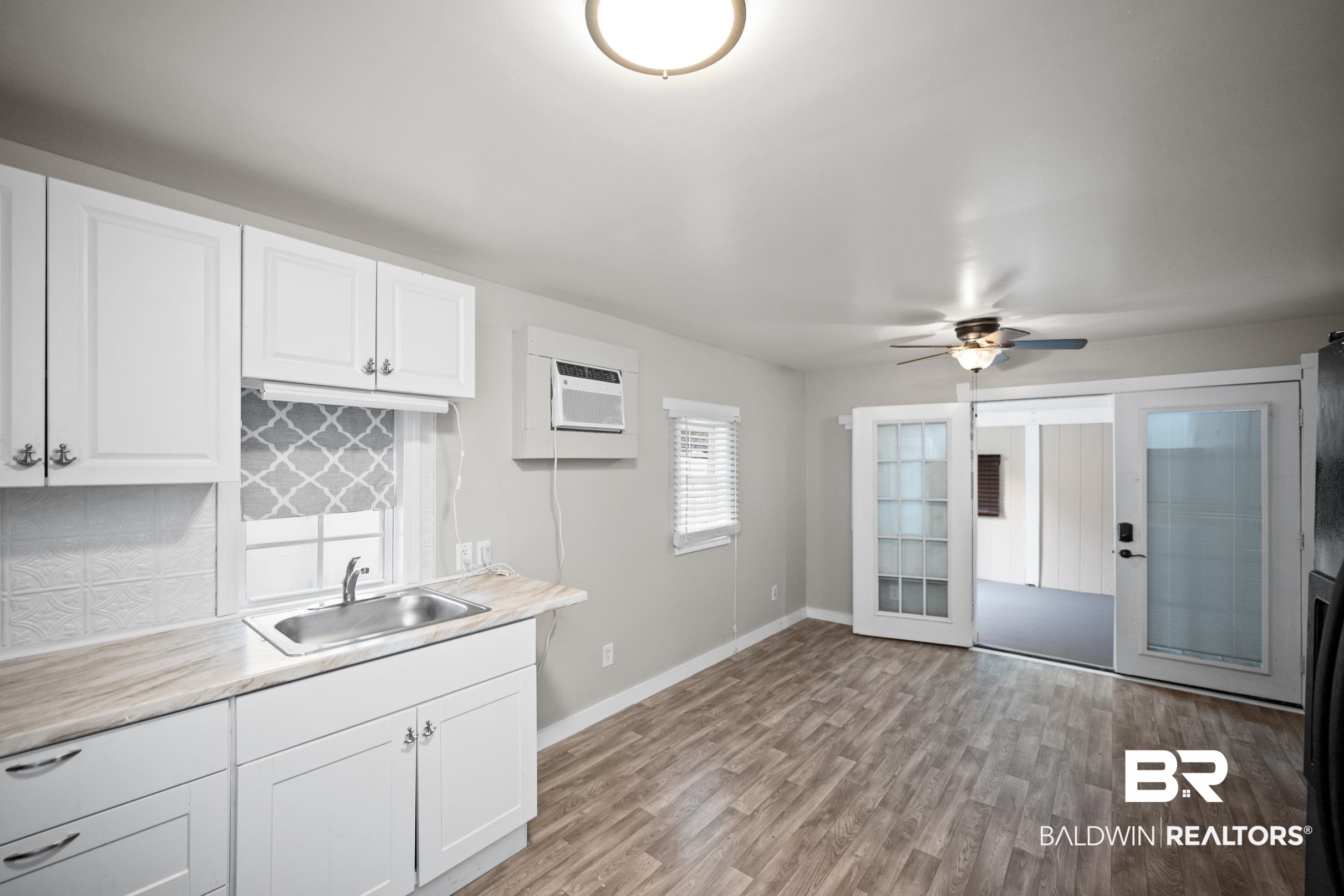 496 Elberta Loop Lillian, AL 36549 - Photo 13 of 29 Kitchen featuring a wall mounted AC, tasteful backsplash, white cabinetry, light countertops, and ceiling fan