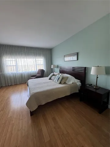 a spacious bedroom with a bed and a flat screen tv