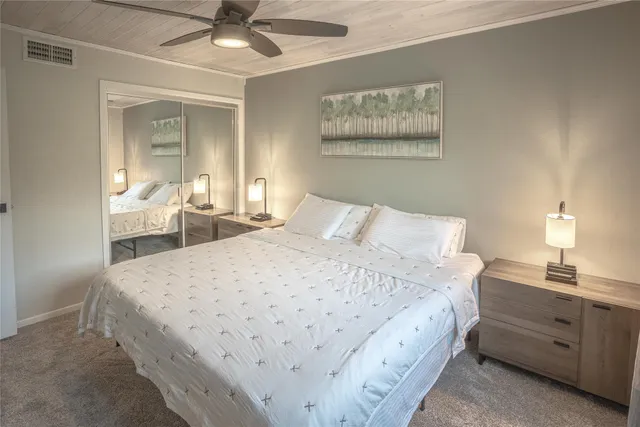 a spacious bedroom with a bed and a chandelier