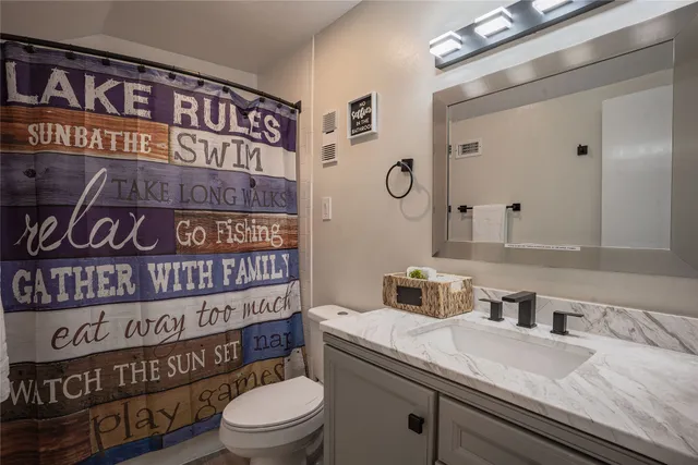 a bathroom with a sink a toilet and a mirror