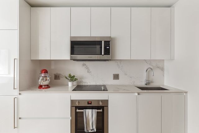a kitchen with a microwave a sink and cabinets