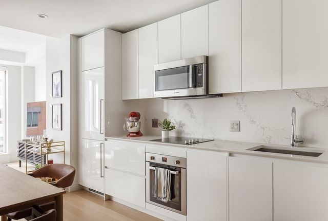 a kitchen with stainless steel appliances granite countertop a sink stove and cabinets