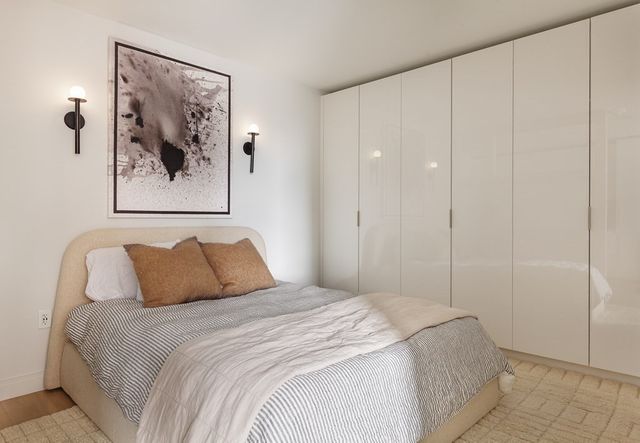 a bedroom with a bed and a painting on the wall